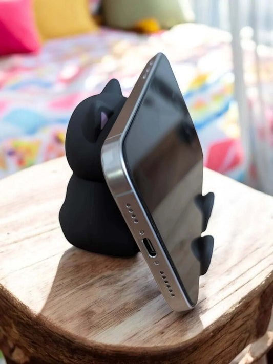 Mini Portable Speaker - Black Cat used as phone stand on table.